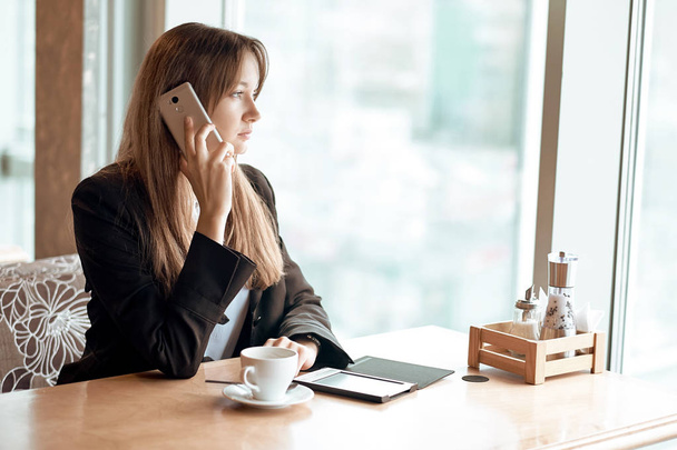 Young business woman talking on the phone in coffee shop - Foto, Imagem