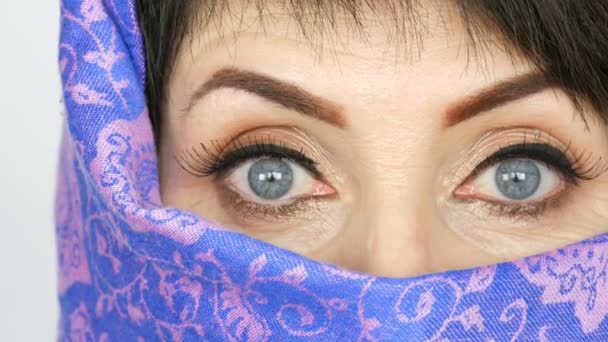 Portret van een Arabisch middelbare leeftijd volwassen vrouw met ongewone mooie grote blauwe ogen met lange wimpers in de traditionele islamitische doek niqab of boerka. Close-up van de mooie Moslimvrouw - Video