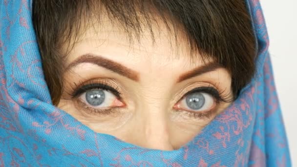 Portré egy arab középkorú felnőtt nő szokatlan gyönyörű nagy kék szeme hosszú szempillák a hagyományos iszlám ruhával Niqab vagy kék burqa. Közelről gyönyörű muzulmán nő - Felvétel, videó