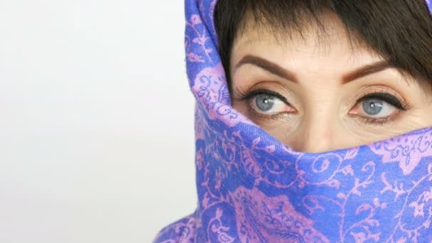 伝統的なイスラムの布 niqab やブルカで長いまつげと珍しい美しい大きな青い目を持つアラビアの中年の大人の女性の肖像画。美しいイスラム教徒の女性のクローズアップ - 映像、動画