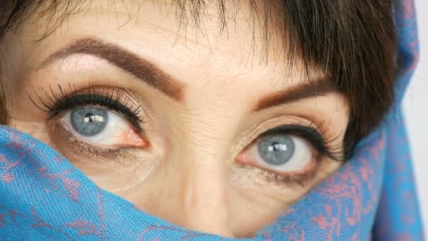 Portrait of an arabic middle aged adult woman with unusual beautiful big blue eyes with long eyelashes in traditional islamic cloth niqab or blue burqa. Close up of beautiful muslim woman - Footage, Video