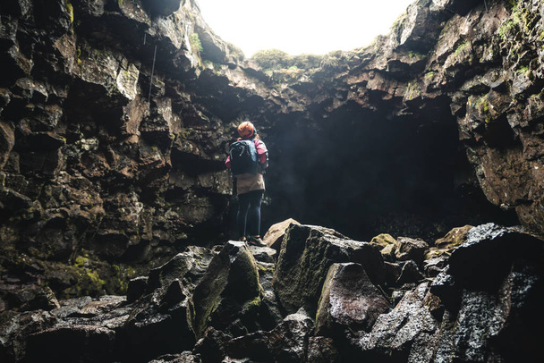 Woman traveler explore lava tunnel in Iceland. - Fotoğraf, Görsel