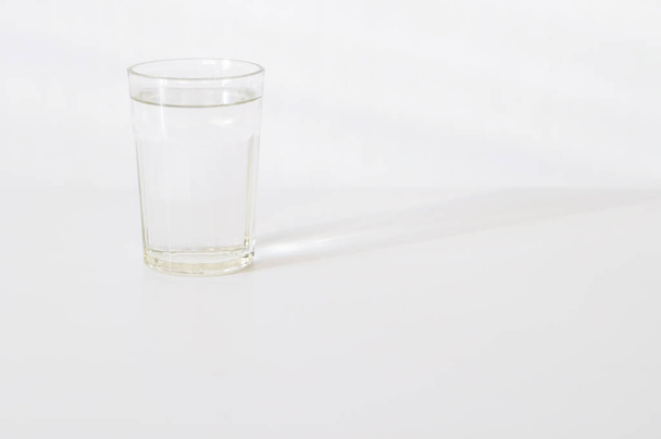Water in transparent glass on gray background. purified fresh drink water on table - Fotoğraf, Görsel