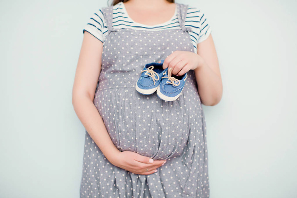 terhes nő kis baba cipő - Fotó, kép