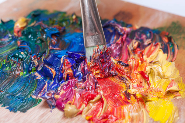 Verfborstel gemengd verschillende kleuren olieverf. kleurrijke acryl. modern kunstconcept - Foto, afbeelding