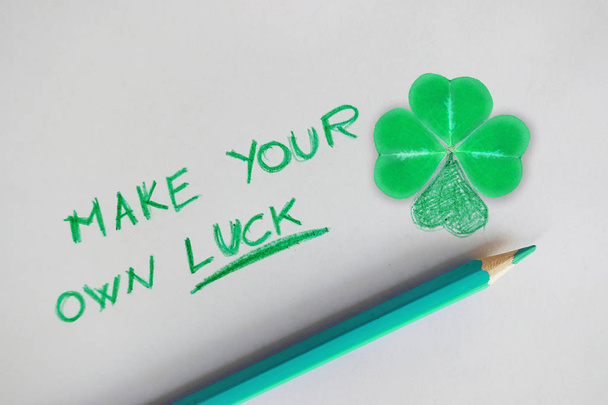 Haga su propio texto de la suerte en el papel blanco cerca de trébol de cuatro hojas como símbolo de la suerte
 - Foto, Imagen