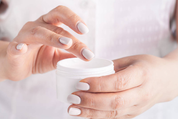 Volwassen vrouw toepassing hand crème, close-up - Foto, afbeelding