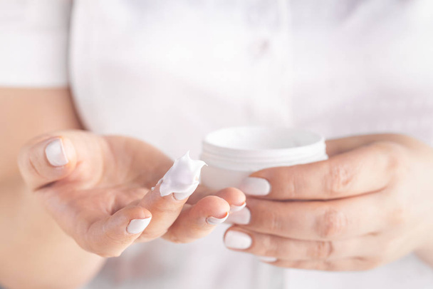 Closeup shot of woman hands applying moisturizing hand cream - Foto, afbeelding