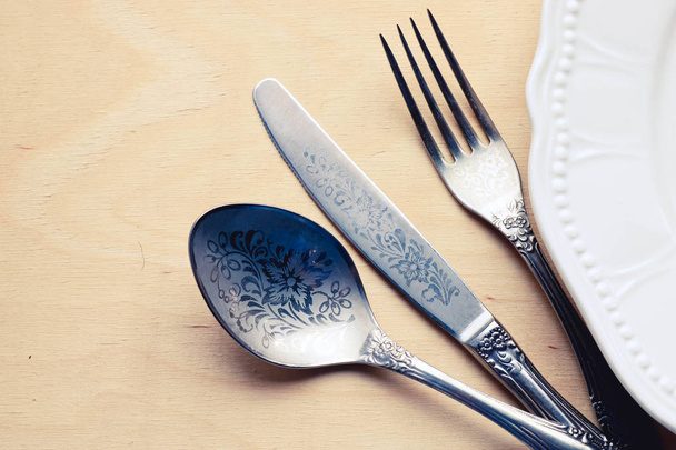 Spoon fork and knife near whiye plate. Restaurant concept. - Foto, imagen