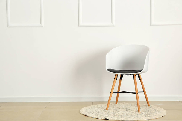 Elegante silla cerca de la pared blanca en la habitación - Foto, Imagen
