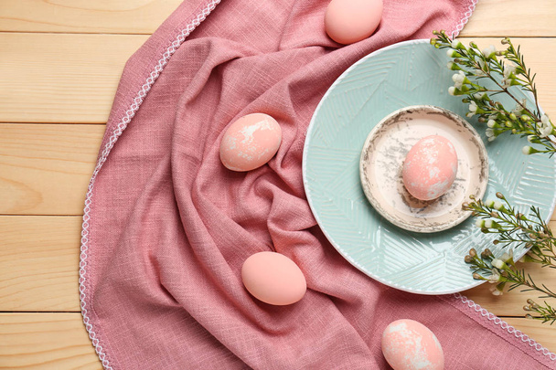 Plates with Easter eggs on wooden table - Foto, afbeelding