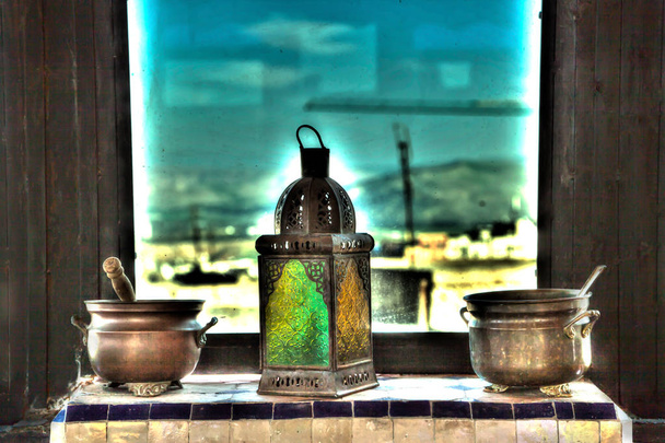 Vasen, Töpfe und Lampen wie aus Tausend und einer Nacht im orientalischen Stil mit prachtvollen Ornamenten und Dekorationen vor einem Fenster mit farbigen Fensterscheiben - Foto, Bild