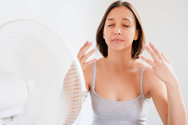Žena osvěžující před elektrický ventilátor ventilátor - Fotografie, Obrázek
