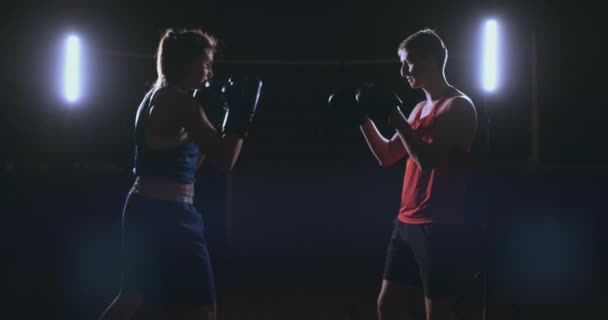 фитнес-спортсменка бокс перчатки пробивая фокус наслаждаясь интенсивными упражнениями женщина боец тренировки друг в тренажерном зале тренировки вместе замедленное движение
 - Кадры, видео