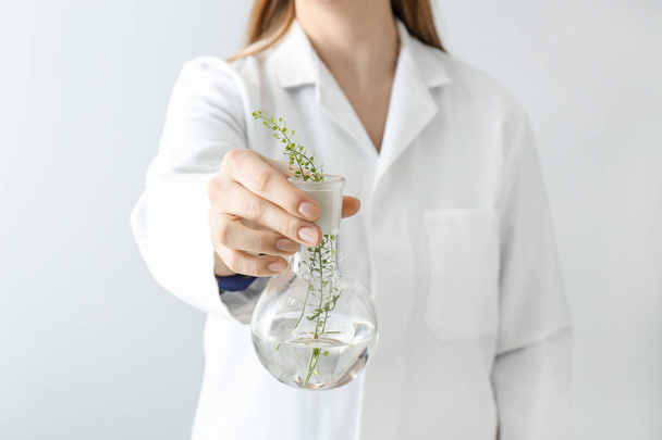 Doutor segurando frasco com plantas, close-up
 - Foto, Imagem