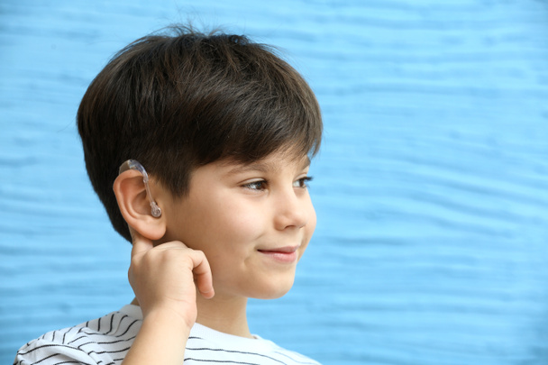 Мальчик со слуховым аппаратом на цветном фоне
 - Фото, изображение