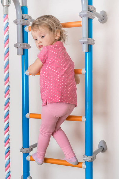 Little happy girl climbing the ladder - Foto, immagini