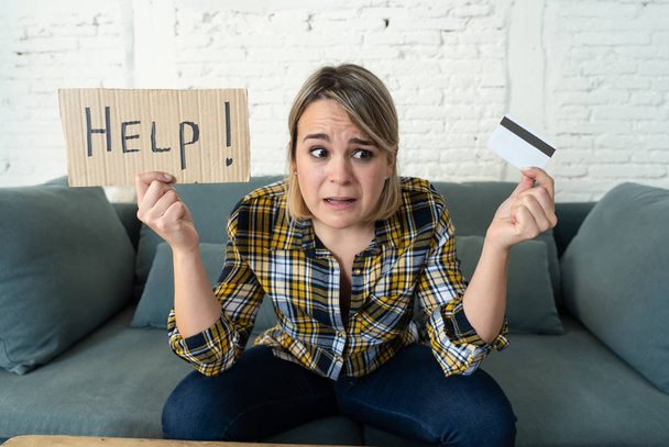 Portrait of worried young woman feeling stressed with too much credit card debts trying to manage business and home finances showing Help sign. In paying off debts, bills and financial problems. - Foto, afbeelding