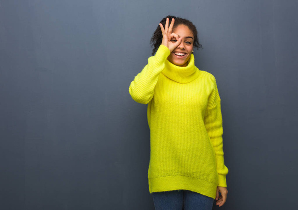 Young black woman confident doing ok gesture on eye - Valokuva, kuva