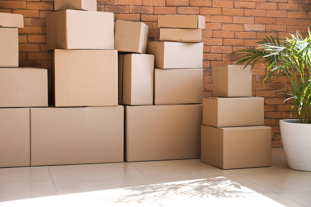 Moving boxes near brick wall in room - 写真・画像