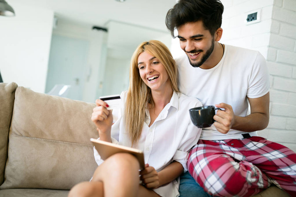 Happy couple in love using tablet in pajamas at home - Foto, Imagem