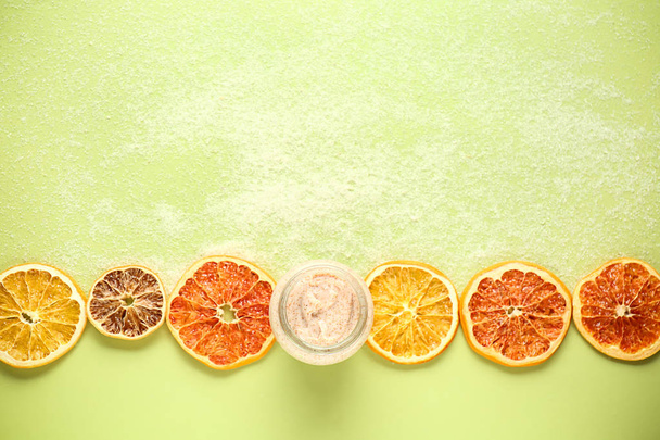 Sklenice cukrový peeling s citrusové řezy na barvu pozadí - Fotografie, Obrázek