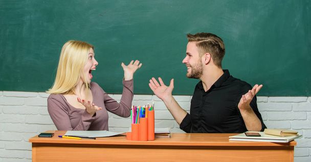 Celebrating success. Happy couple studying in classroom. Man and woman back to school. Pretty teacher and handsome schoolmaster. University or college students having lesson. High school education - Photo, Image