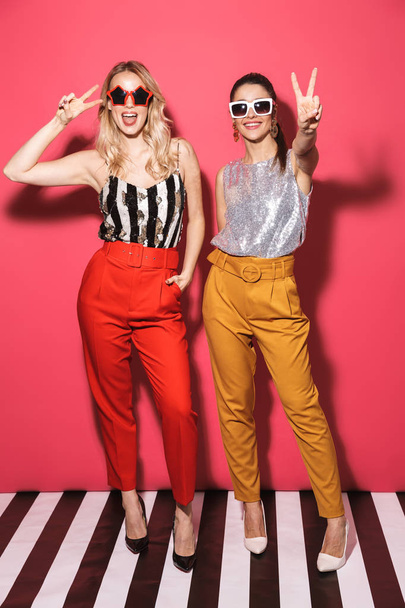 Full length photo of two fancy women 20s in trendy outfit smilin - Foto, afbeelding