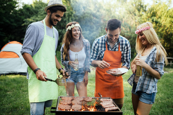 Friends having fun grilling meat enjoying bbq party - Фото, зображення