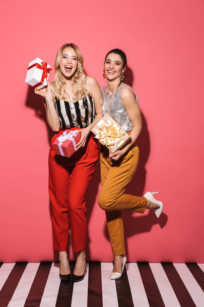 Portrait of two joyful girls 20s in stylish outfit on party hold - Foto, imagen