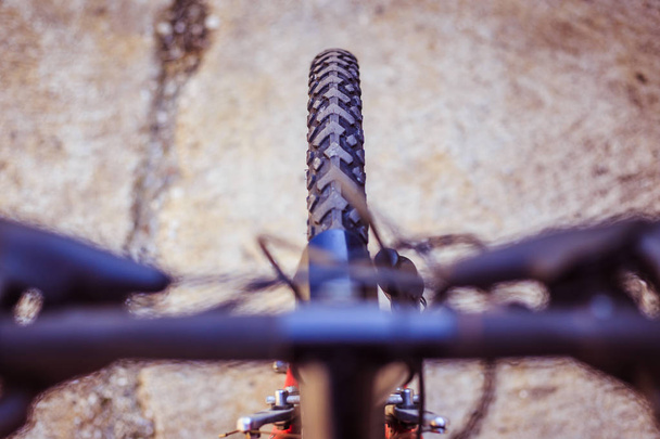 Mountain bike tyres outside, blurry handlebar, summer day, city  - Photo, image