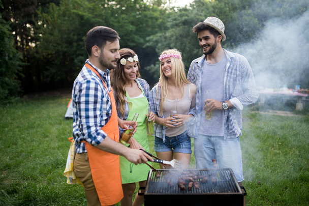 Friends having fun grilling meat enjoying bbq party - Valokuva, kuva