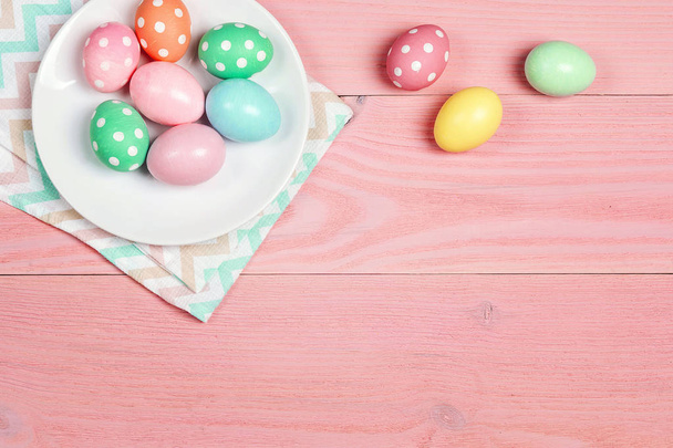 Easter eggs on the plate on pink wooden table. Copy space for te - Фото, изображение