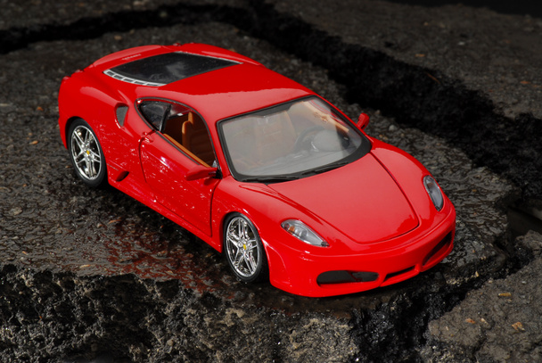 Rouge, moderne, jouet, machine de course sur le trottoir sur un fond sombre
 - Photo, image