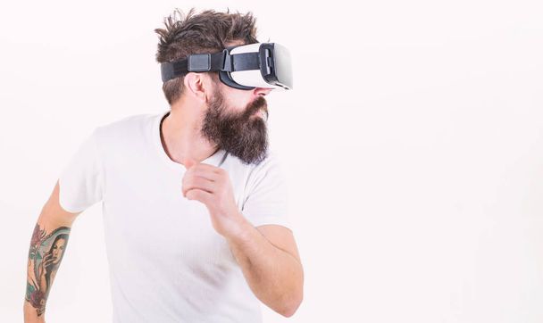 Virtual reality game concept. Cyber sport. Guy with head mounted display interact virtual reality. Hipster play virtual sport game. Virtual race. Man bearded gamer VR glasses white background - Φωτογραφία, εικόνα