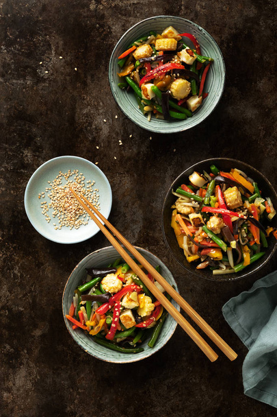 Verdura in ciotola mescolare friggere sul wok su sfondo scuro concreto
 - Foto, immagini