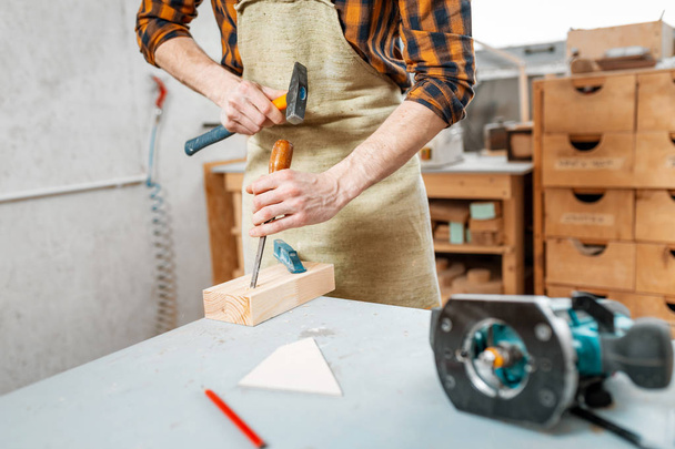 Ο άνθρωπος ξυλουργό που εργαζόταν με ένα σφυρί και μια σμίλη, γκρο πλαν του  - Φωτογραφία, εικόνα