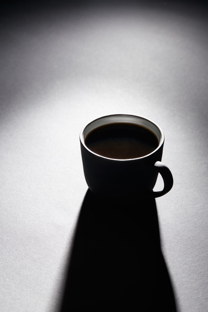 Cup of black coffee on dark textured surface - Фото, изображение