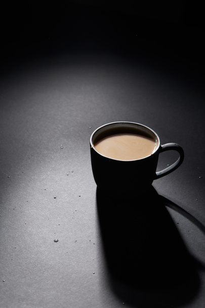 Cup of coffee with milk on dark textured surface - Fotó, kép