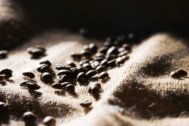 Selective focus of roasted coffee grains on sackcloth texture - Fotografie, Obrázek