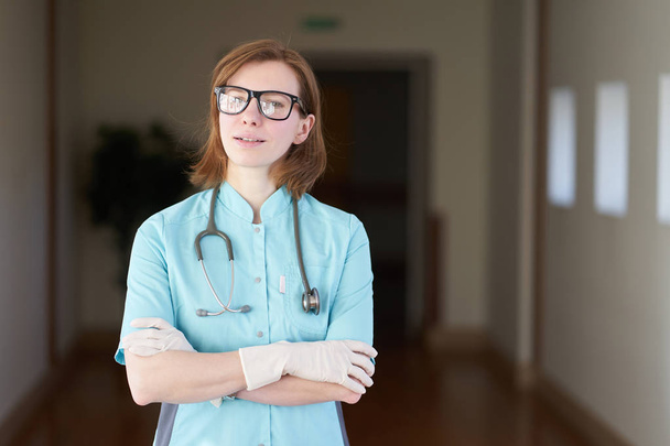 Lächelndes Porträt einer weißen rothaarigen Ärztin mit Stethoskop am Hals - Foto, Bild