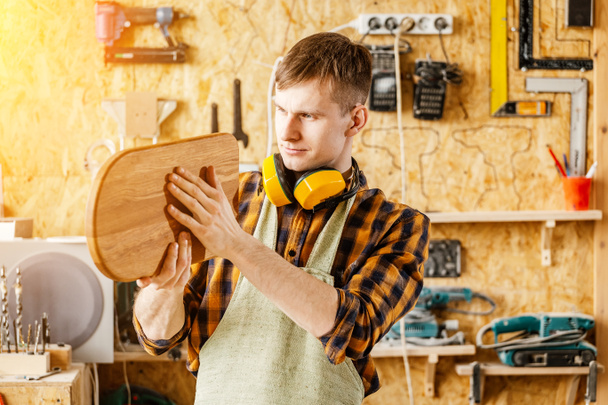 Cieśla człowieka posiadania produktu gotowego, z drewna - cięcie  - Zdjęcie, obraz