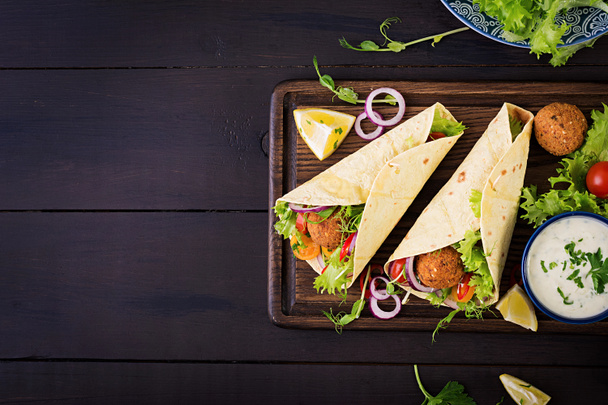 Tortilla wrap with falafel and fresh salad. Vegan tacos. Vegetarian healthy food. Top view - Photo, Image