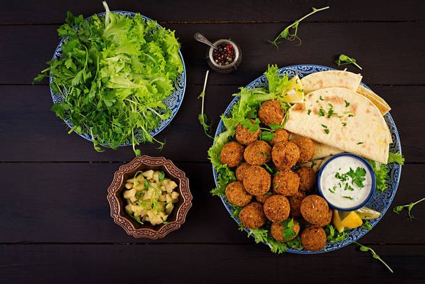 Falafel, Hummus und Pita. Nahöstliche oder arabische Gerichte auf dunklem Hintergrund. Halal-Lebensmittel. Ansicht von oben. Kopierraum - Foto, Bild