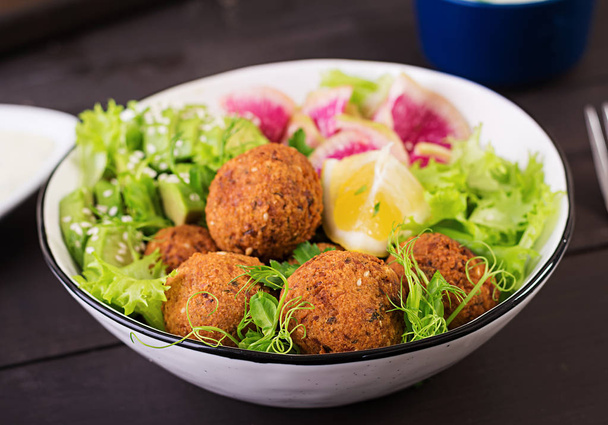 Falafel en verse groenten. Buddha bowl. Midden-Oosten of Arabische gerechten op een donkere achtergrond. Halal voedsel. - Foto, afbeelding