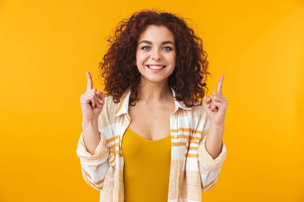 Image of young woman 20s with curly hair smiling and pointing fi - Photo, image