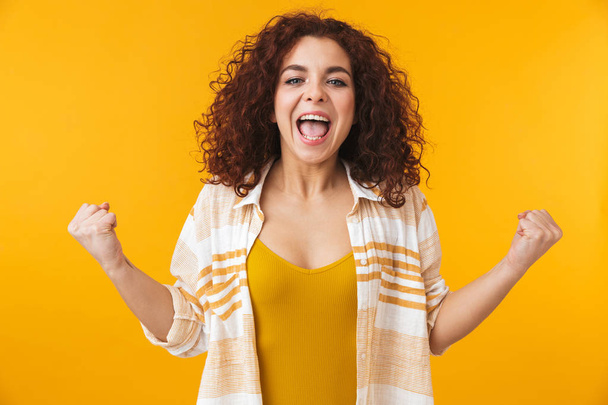 Image of ecstatic woman 20s with curly hair screaming and rejoic - Фото, зображення