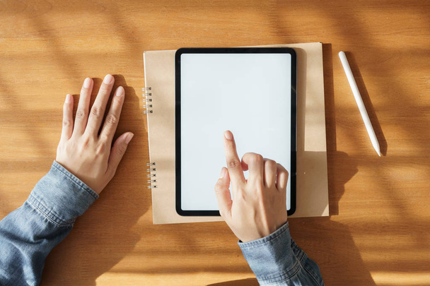 Mujer asiática usando la tableta con la pantalla blanca en la mano artículo de la tecnología de la pantalla táctil
 - Foto, Imagen