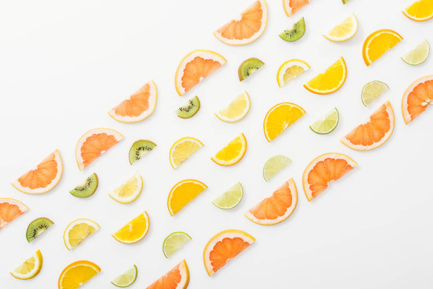 Flat lay with juicy cut fruits on white surface - Фото, изображение