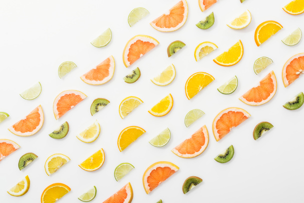 Flat lay with juicy cut fruits on white surface - Foto, Imagen